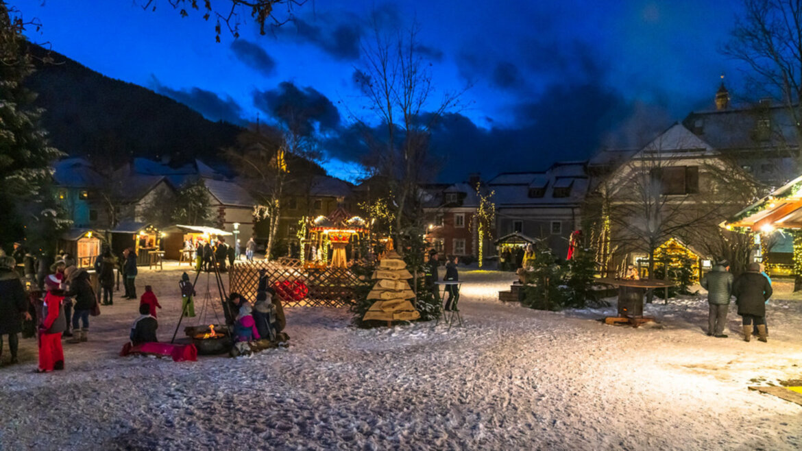 Mercatino dell’Avvento nel Parco del castello di Tamsweg nel Lungau illuminato dalle luci al crepuscolo (Vista ingrandita)