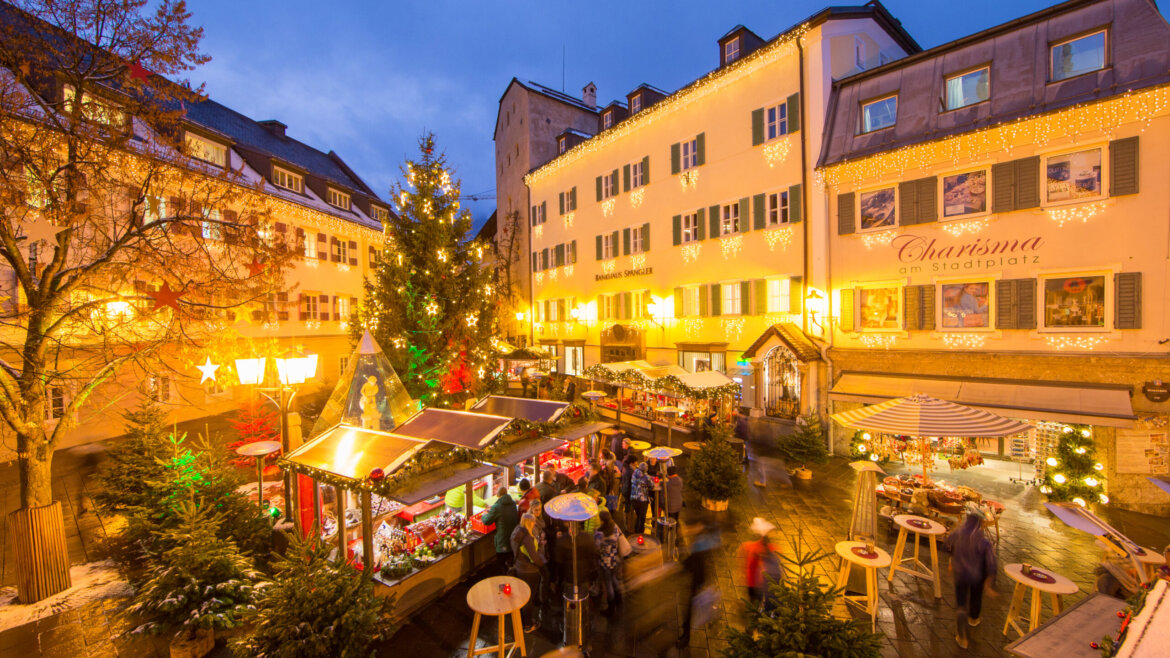Mercatino dell’Avvento delle Stelle (Sternenadvent) nel centro storico di Zell am See con luci e bancarelle festive (Vista ingrandita)