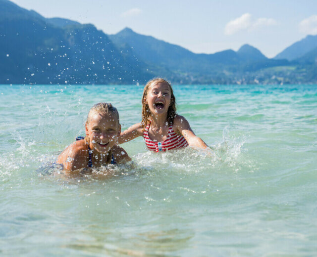Bambini che giocano e si divertono nelle acque del lago Wolfgangsee nel Salisburghese