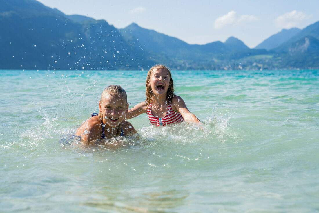 Bambini che giocano e si divertono nelle acque del lago Wolfgangsee nel Salisburghese
