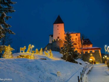 Castello di Mauterndorf illuminato con figure natalizie visto dal sentiero nel Lungau salisburghese