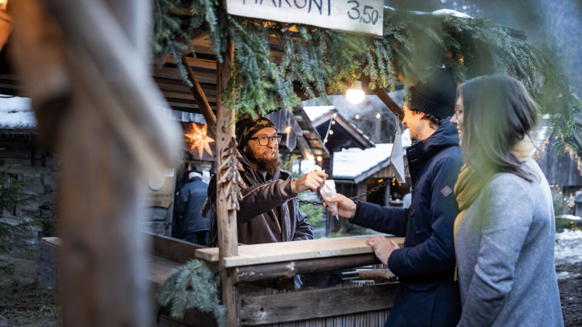 Coppia che prende un cono di caldarroste durante l’Avvento sulle montagne intorno a Gosau nel Salzkammergut (Vista ingrandita)