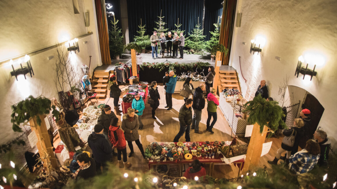 Cinque cantanti si esibiscono al mercatino d’Avvento nel Castello di Mauterndorf nel Lungau salisburghese davanti al pubblico (Vista ingrandita)