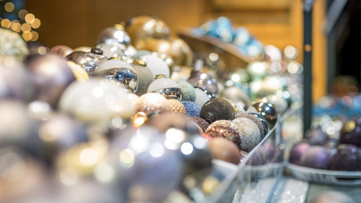 Decorazioni natalizie in vetro al Mercatino di Gesù Bambino di Salisburgo tra riflessi di luce e sfere colorate (Vista ingrandita)