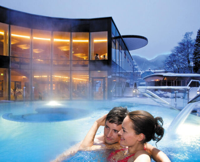 Coppia che si rilassa nella piscina esterna riscaldata dell’EurothermenResort di Bad Ischl in un paesaggio invernale