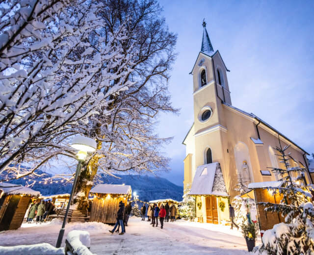 Chiesa di Santa Croce e Sant’Elisabetta a Guggenthal con il mercatino dell’Avvento dei villaggi nella regione del lago Fuschlsee nel Salisburghese