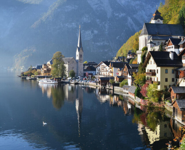 Veduta di Hallstatt, il villaggio più bello dell’Austria e famoso in tutto il mondo, con case colorate, due chiese e il riflesso delle montagne sul lago nella regione Dachstein Salzkammergut
