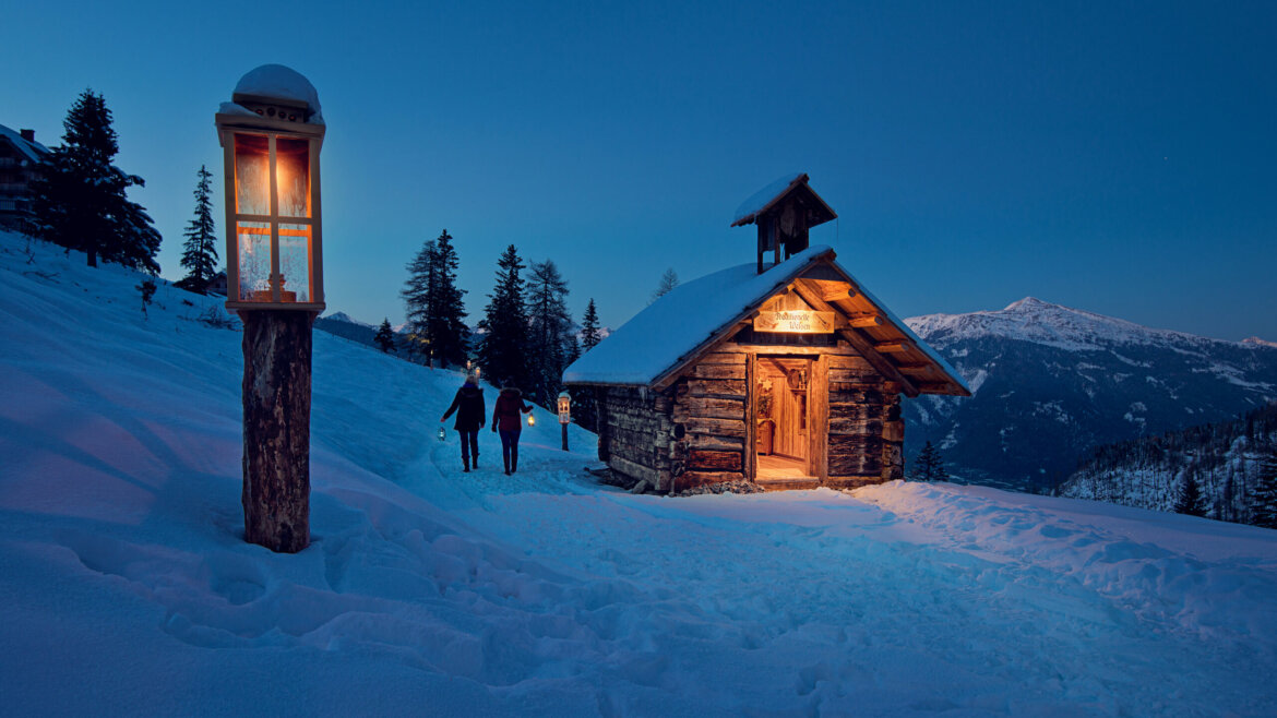 Persone lungo il sentiero dell’Avvento del Katschberg al crepuscolo con montagne sullo sfondo (Vista ingrandita)