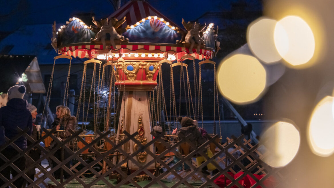 Bambini che si divertono su una giostra a catene nel Parco del castello di Tamsweg nel Lungau durante il mercatino d’Avvento (Vista ingrandita)