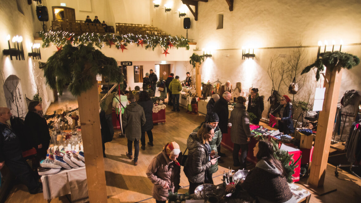 Mercatino d’Avvento nel Castello di Mauterndorf nel Lungau salisburghese con bancarelle negli interni della fortezza e atmosfera intima (Vista ingrandita)