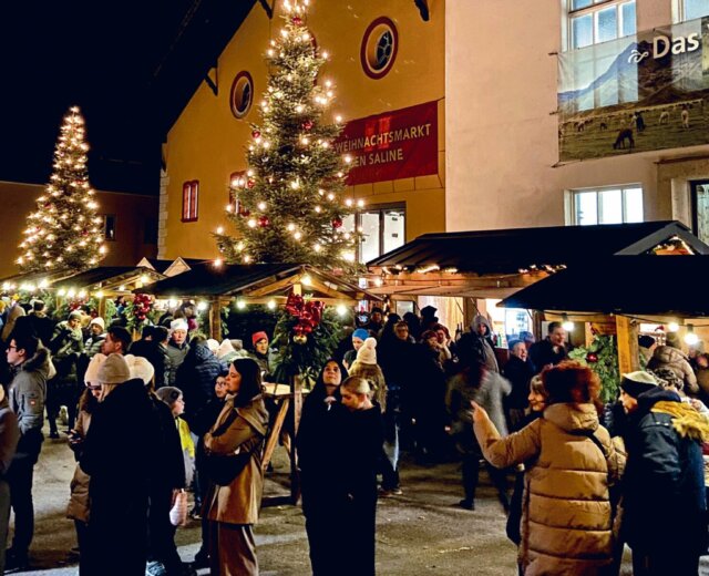Mercatino di Natale all’esterno dell’Antica Salina di Hallein con numerosi visitatori tra luci e bancarelle