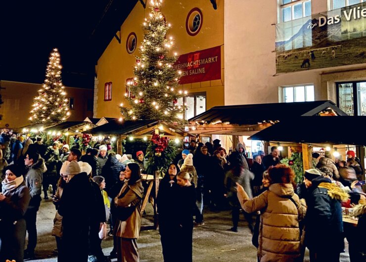 Mercatino di Natale all’esterno dell’Antica Salina di Hallein con numerosi visitatori tra luci e bancarelle