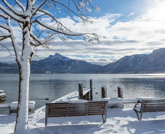 Passeggiata lungo il lago Mondsee coperta di neve in una soleggiata giornata d’inverno