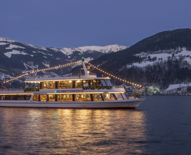Nave “MS Schmittenhöhe” illuminata durante l’Avvento delle Stelle con la montagna Schmittenhöhe sullo sfondo