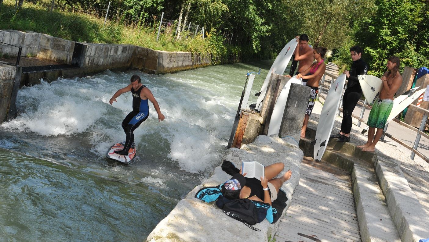 Surfista che cavalca la celebre onda del Canale della Malga rispettivamente Almkanal a Salisburgo con spruzzi d’acqua