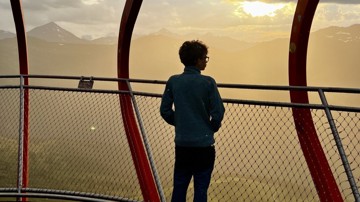 Uno sguardo sulle montagne della Valle di Gastein al tramonto dalla piattaforma panoramica Glocknerblick sullo Stubnerkogel. © Azzurra Forti – BabyTrekking Federico sulla piattaforma panoramica Glocknerblick sullo Stubnerkogel, mentre osserva le montagne al tramonto attraverso le caratteristiche strutture metalliche rosse. (Vista ingrandita)