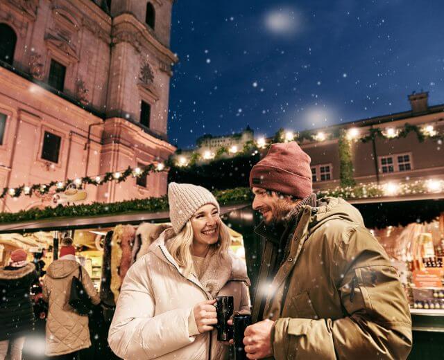 Paar trinkt Glühwein am Adventmarkt