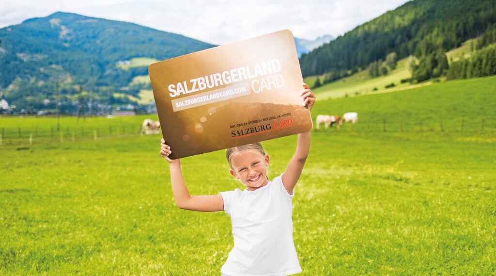 Een meisje houdt de SalzburgerLand Card omhoog