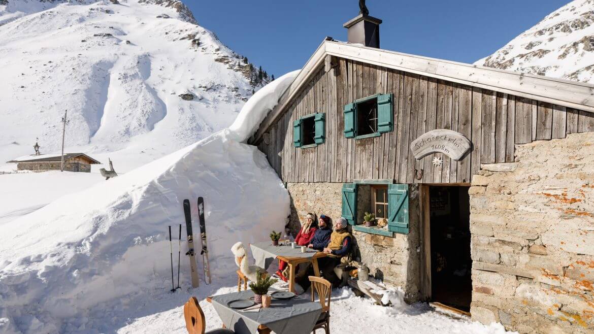 Skifahrer sonnen sich auf der Hütte