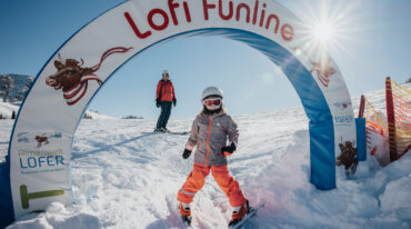 Almenwelt Lofer Lofi Funline – kind met mama in het funpark met ski’s.