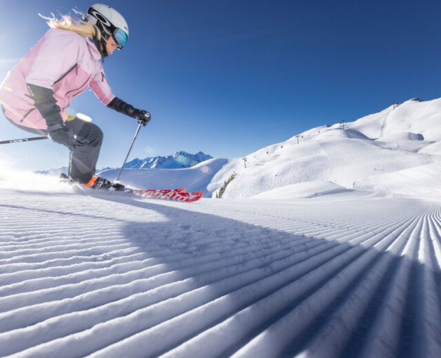 NPHT_Raurisertal_Skifahren ©Hochalmbahnen AG Een skiester maakt elegante bochten op de perfect geprepareerde piste.