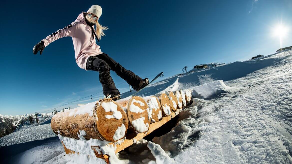 Odważne i kreatywne zjazdy na snowboardzie po przeszkodach w snowparku Burton Stash Park we Flachauwinkl .