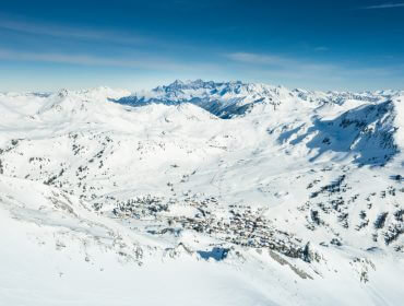 Małe miasteczko położone jest w zaśnieżonej górskiej dolinie Obertauern pod czystym, błękitnym niebem.