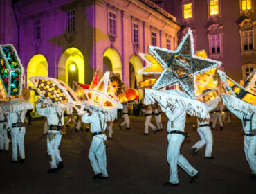 Glöcklerlauf Ludzie w białych strojach niosą gwiezdne latarnie podczas najważniejszych nocnych imprez na Ziemi Salzburskiej.