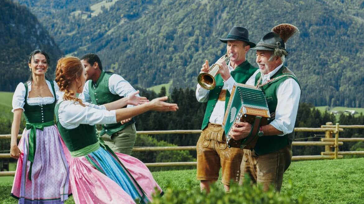 Festyn z muzyką i tańcami w strojach ludowych na alpejskiej łące przy gospodarstwie Winterstellgut w Annaberg-Lungötz.