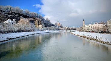 Zimowy widok z kładki Marko-Feingold-Steg na rzekę Salzach i zabytkowy kwartał Mülln w Salzburgu