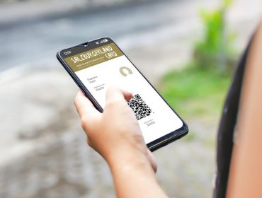 Osoba trzymająca smartfon z kodem QR online karty SalzburgerLand Card na zewnątrz.