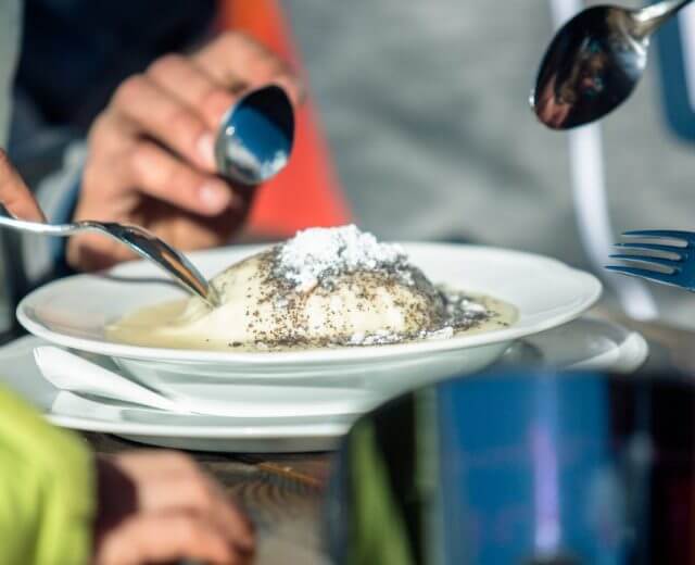 a-13_kulinarik_obertauern-1170×658 Knedel drożdżowy na parze ze śliwkowym nadzieniem, w sosie waniliowym i z makową posypką to słodka klasyka kuchni alpejskiej.