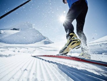 Ciesz się narciarstwem biegowym Zell am See-Kaprun na przygotowanym śniegu z widokiem na słońce i góry.