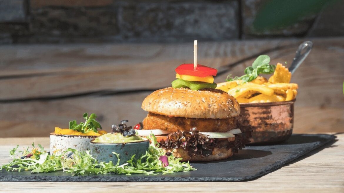 Burger wegetariański z sałatą i papryką, frytki oraz sałatka — kulinarne atrakcje na świeżym powietrzu w Hochkönig zachwycają.