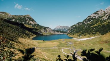 Alpejska panoramam z zielonymi halami, wapiennymi szczytami i jednym z najpiękniejszych jezior w Alpach, Tappenkarsee