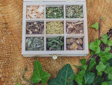 Drewniane pudełko z dziewięcioma przegródkami na suszone zioła i żywice, inspirowane Tradycyjną Medycyną Europejską.