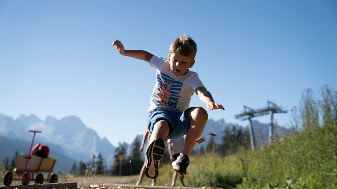 Chłopiec próbuje swoich sił w skoku w dal w parku Brunos Bergwelt.