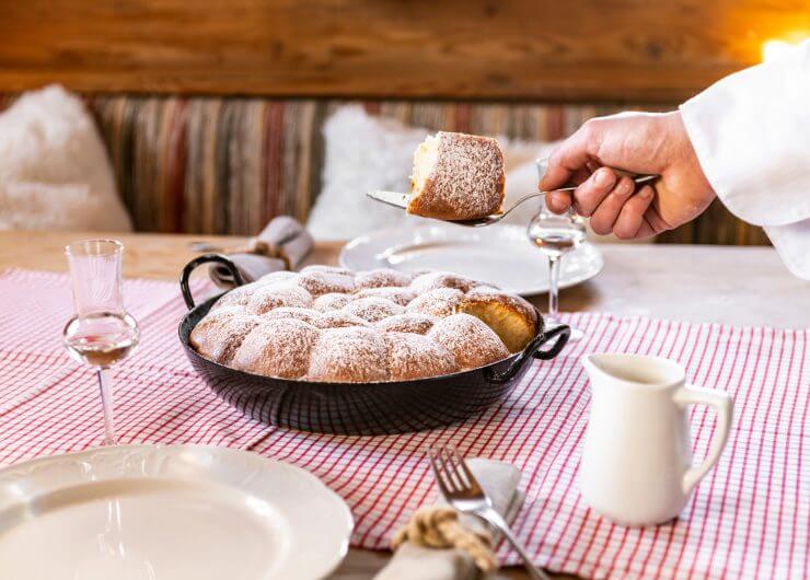 Tradycyjne salzburskie buchty to drożdżwe bułeczki wypełnione dżemem morelowym, oprószone cukrem pudrem i polane sosem waniliowym.