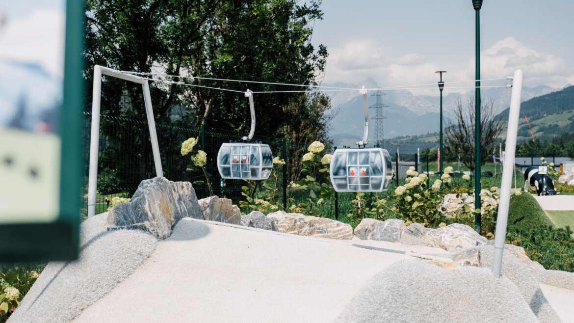 Dwa małe modele kolejek linowych szybują nad skalistym krajobrazem, przywołując na myśl sport i zabawę w St. Johann. (Powiększony widok)