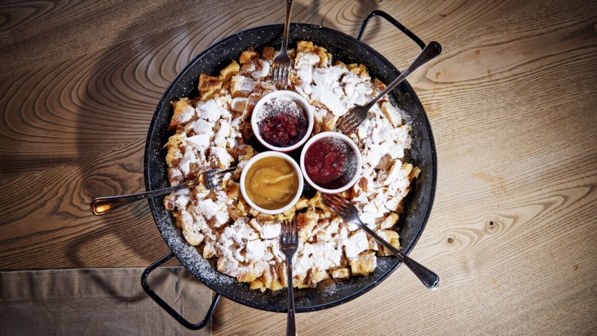 Kaiserschmarrn na patelni z sosami owocowymi i widelcami, serwowany podczas festiwalu Zima w Mittersill.